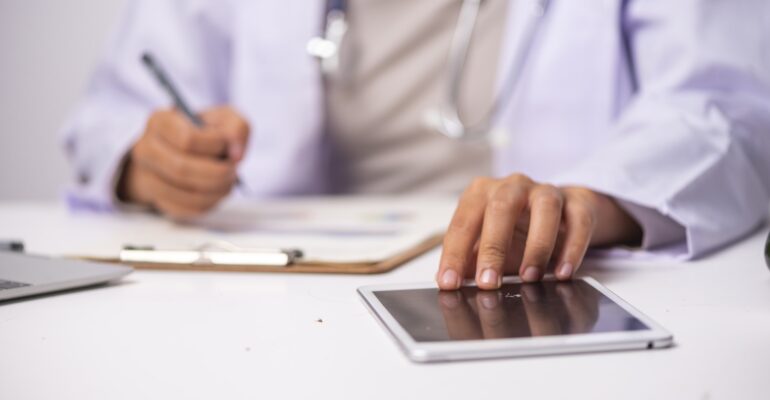 doctor hand writing prescription on paper. Top view of hand of doctor writing
